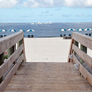 Walkway down to beach with umbrellas and chairs in Orange Beach, Alabama